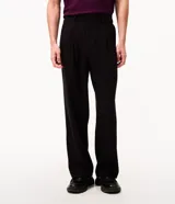 Pantalón de vestir beige de corte wide leg, con trabillas para cinto, bolsillos y diseño de sastrería.