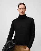 Sweater de punto cardado color negro, con cuello chimenea y manga larga. Confeccionado en una mezcla de mohair y liocel que proporciona ligereza, calidez y un tacto suave. Presenta un diseño minimalista con una caída fluida y brillo sutil.
