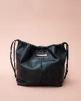 Cartera tipo tote de cuero color bordó, con diseño fruncido en los laterales y abertura central integrada como asa. Presenta una silueta flexible y espaciosa, ideal para uso diario.