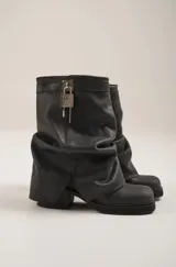 Botas marrones de cuero con caña arrugada, suela track y detalle de candado plateado.