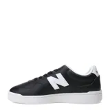 Championes urbanos New Balance de estilo court, color negro con detalles en blanco. Presentan el logo 'N' en el lateral, puntera perforada y suela de goma blanca.