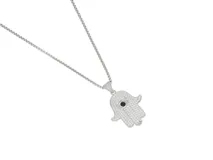 Collar con cadena de acero y dije en forma de mano de Hamsa, cubierto de circonias blancas con un detalle central de piedra negra en forma de ojo.