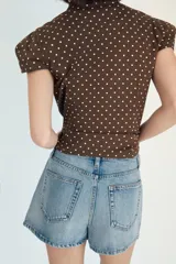 Falda pantalón de tiro medio confeccionada en denim, con bolsillos delanteros y cierre frontal con cremallera y botón metálico.