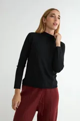 Polera de tejido de punto fino color bordó, con cuello alto y mangas largas.