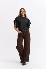 Remera negra de algodón con mangas cortas que presentan volados dobles, aportando volumen y movimiento a la prenda.