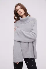 Sweater de punto con cuello alto tipo polera, de calce holgado y mangas largas con diseño acampanado.