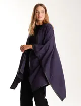 Ruana de tejido suave color azul oscuro, con vivos de ecocuero negro en los bordes.