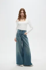 Pantalon de jean estilo wide leg con tiro medio, bolsillos laterales y traseros, y ruedo desflecado.
