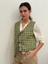 Chaleco verde claro con diseño acolchado y estampado a cuadros, sin mangas y con tiras para anudar en el frente.