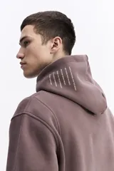 Canguro de felpa color crema, con capucha y bolsillo canguro frontal. Presenta un pequeño estampado con el logo de la marca en el pecho.