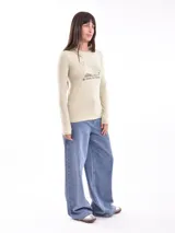 Remera de manga larga color gris oscuro, ajustada al cuerpo, con un estampado frontal de flores y texto en color blanco.