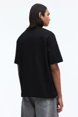 Remera de corte holgado confeccionada en punto interlock de algodón, con cuello redondo acanalado, hombros caídos y bajo recto.