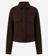 Campera de sarga acanalada color marrón, con cuello camisero estructurado, cierre frontal con botones, mangas largas con puños y bolsillos delanteros con solapa.