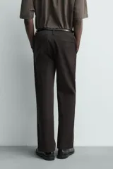 Pantalón chino regular fit de color negro, confeccionado en tejido de algodón. Cuenta con bolsillos frontales, detalle de bolsillo cerillero, bolsillos traseros de doble vivo y cierre frontal con cremallera y botón.