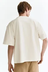 Remera de algodón pesado color blanco con cuello redondo acanalado, hombros caídos y corte holgado de silueta boxy.