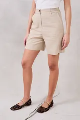 Bermuda color beige de lino y viscosa, tiro medio, corte recto y largo a la rodilla.