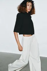 Blazer cropped de corte estructurado, con cuello subido, manga corta y cierre frontal con un botón. Presenta un bolsillo de vivo en el pecho y forro interior a tono.