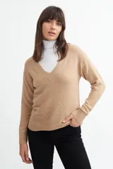 Sweater color beige con escote en V profundo y corte holgado.