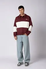 Buzo tipo polo de calce relajado, con diseño de bloques de color en bordó y blanco. Presenta cuello camisero con cierre de botones oculto y logo bordado en el pecho.