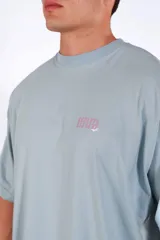 Remera oversize de algodón celeste con estampado frontal en color rosado.