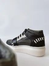 Zapatillas deportivas de caña alta con estampado de piel de reptil en tonos verde y negro, detalles en blanco y suela gruesa blanca.