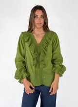 Blusa de algodón blanca con escote en V, mangas largas amplias y detalles de volados con encaje bordado en el frente.