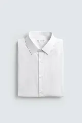 Camisa slim fit blanca de manga larga, cuello italiano y puños con botón. Cierre frontal de botonadura.