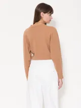 Sweater negro de lana merino con detalle de aro metálico en el frente que frunce la prenda.