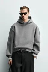 Sudadera tipo hoodie de corte boxy fit, confeccionada en tejido doble y compacto de mezcla de algodón. Presenta cuello con capucha, manga larga y acabados en el mismo tejido.