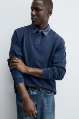 Sudadera polo azul marino de corte regular fit, con cuello solapa en contraste y cierre frontal de botonadura oculta. Tiene manga larga con puños acanalados y un efecto lavado.
