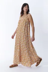 Vestido largo de tirantes en color crudo con estampa geométrica en tonos mostaza, de corte holgado y vuelo fluido.
