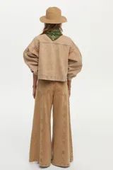 Campera de denim color camel, con diseño boxy, mangas abullonadas y volados frontales decorativos.