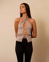 Top color beige con escote halter cruzado y abertura en el centro, con hebillas metálicas.