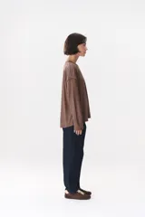 Remera de manga larga con corte oversized, color azul marino con cuello redondo en contraste color marrón. Presenta costuras decorativas a contratono hechas a mano en la zona de los hombros y logo bordado en el centro del pecho.