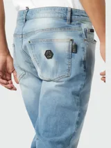 Jeans de corte recto en denim azul claro con efecto lavado. Presentan cierre de botón metálico y bolsillos clásicos.