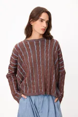 Sweater de punto con diseño de rayas verticales en relieve y textura trenzada, color terracota y beige. Presenta cuello redondo, corte holgado y diseño cropped.