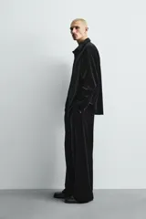Sobrecamisa de corte relajado confeccionada en tejido de terciopelo elástico, con cuello solapa, manga larga con puños abotonados y cierre frontal de botones.