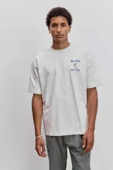 Remera de algodón color gris oscuro, de corte holgado y manga corta, con un pequeño estampado gráfico en el pecho.