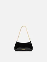 Cartera de cuero negro de silueta curva y diseño estructurado, con manija de cadena metálica dorada y logotipo de la marca en letras metálicas doradas al frente.