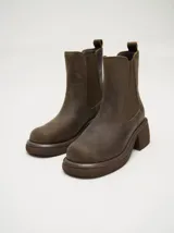 Botas estilo Chelsea de cuero vacuno rojo con grabado texturado tipo paisley, elásticos laterales negros y suela gruesa con taco de 5,5 cm.