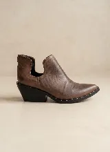 Botín de cuero vacuno color negro, con diseño de corte lateral y taco cuadrado de 5 cm. Presenta punta fina y suela de caucho antideslizante.