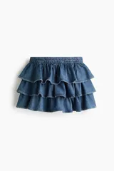 Pollera mini de denim de algodón rígido, con diseño de triple capa de volados escalonados.