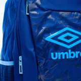 Mochila Umbro modelo Komo, color azul marino con diseño estampado abstracto y logo en celeste. Cuenta con bolsillos laterales de red y asa superior.