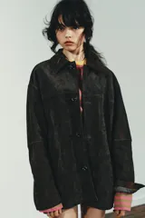 Cazadora oversize de piel de ante 100%, con cuello solapa, manga larga, bolsillos laterales de vivo y bolsillo de plastrón en el pecho. Cuenta con forro interior a tono y cierre frontal con botones.