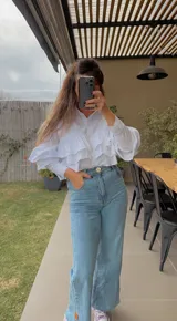 Camisa fucsia de popelina con volados en el frente y mangas largas.