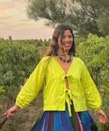 Blusa color verde lima con escote en V, mangas largas abullonadas con puños elásticos y cierre frontal con lazos.