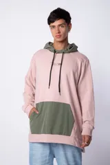 Buzo canguro rosa con capucha verde, cordones negros y bolsillo tipo parche verde en la parte inferior.