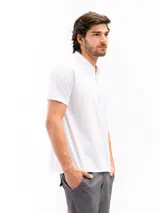 Remera tipo polo de manga corta, color blanco liso, con cuello de polo y tapeta de dos botones.