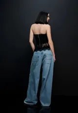 Blusa de encaje negro con escote halter y cordones entrelazados en la parte frontal, de diseño ajustado y espalda descubierta.