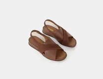 Sandalia de cuero color café con tiras cruzadas en el empeine, talón con elástico interno y plantilla acolchada. Tiene una plataforma ligera y un tacón de 3cm.